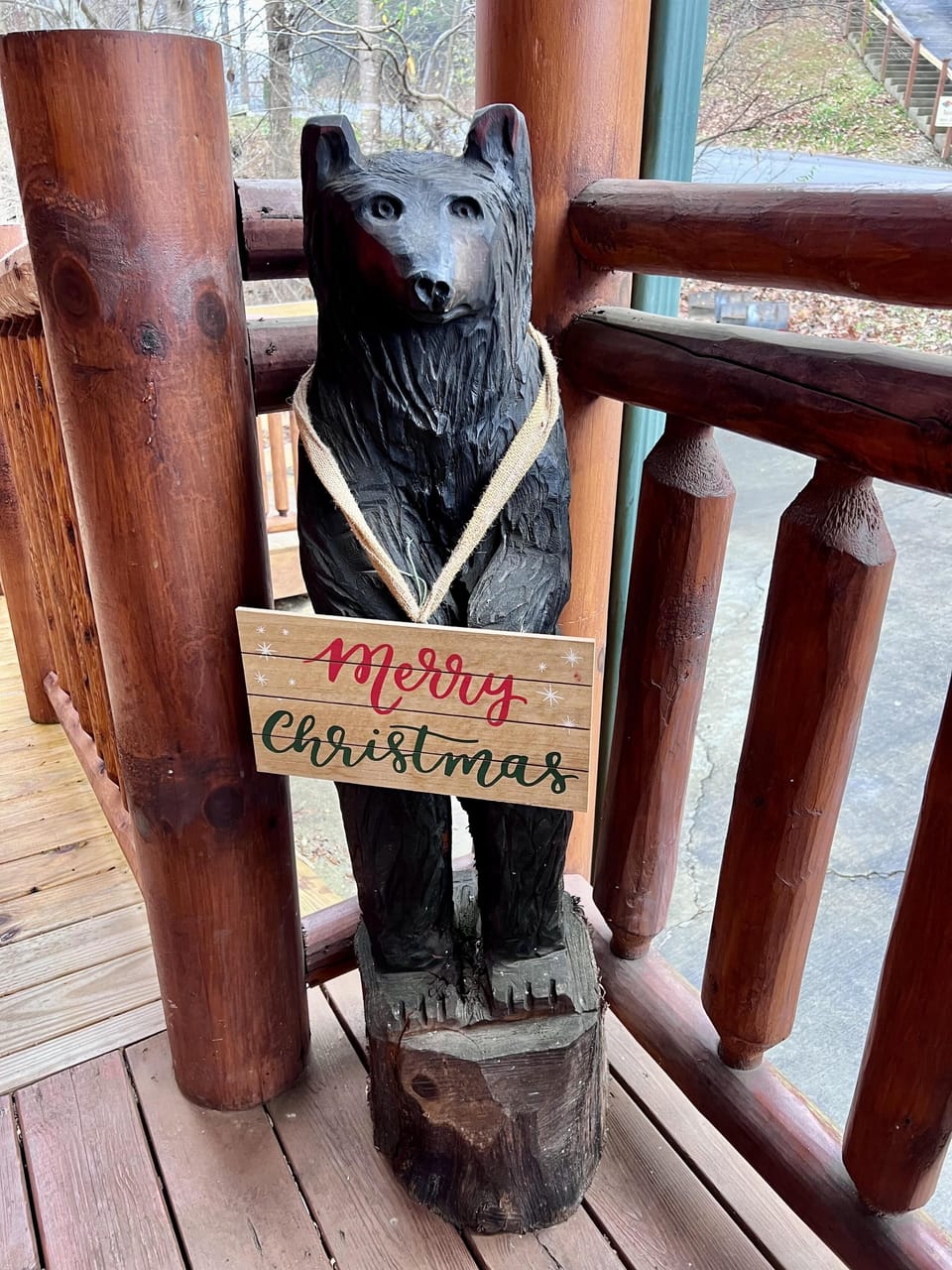 Rustic cabin porch with charming bear statue welcome sign