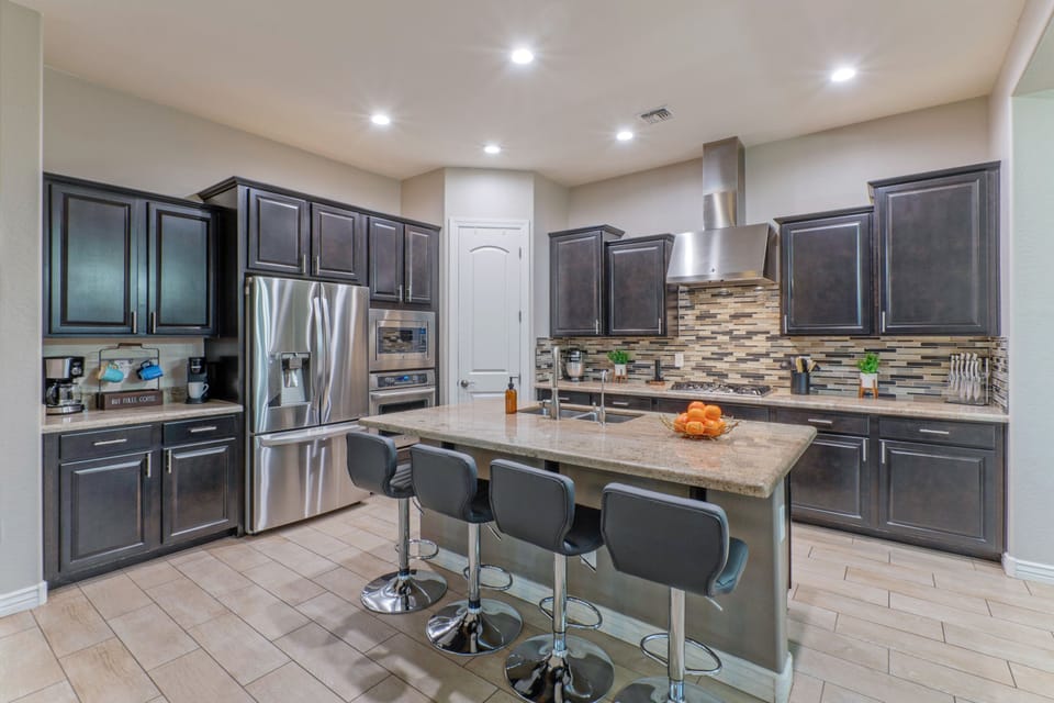 The modern, fully stocked kitchen has island seating for morning coffee and quick meals on the run.