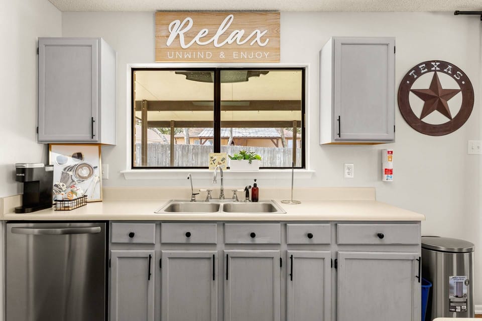Fully stocked kitchen with coffee station, large sink, and backyard views while you cook.