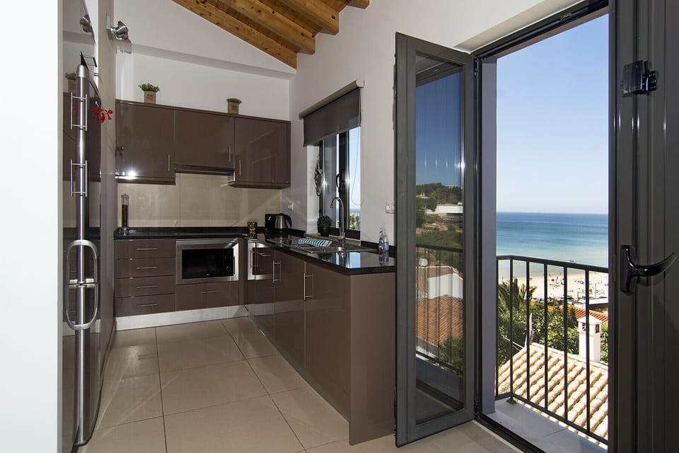 The modern kitchen with electric cooker, oven and dishwasher is located on the west side of the house. So you can enjoy the beautiful view of the beach and Salema while cooking!
