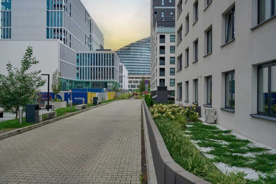 Another perspective of the residential building with parking spaces and landscaped surroundings.
