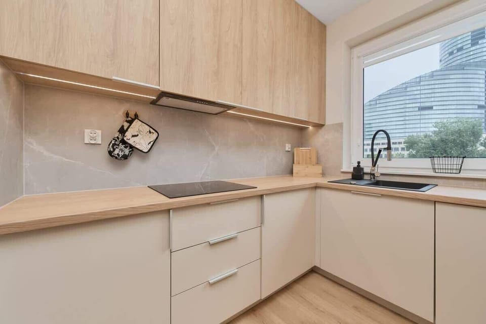 A closer look at the kitchen countertop with light wood cabinetry and modern fixtures.
