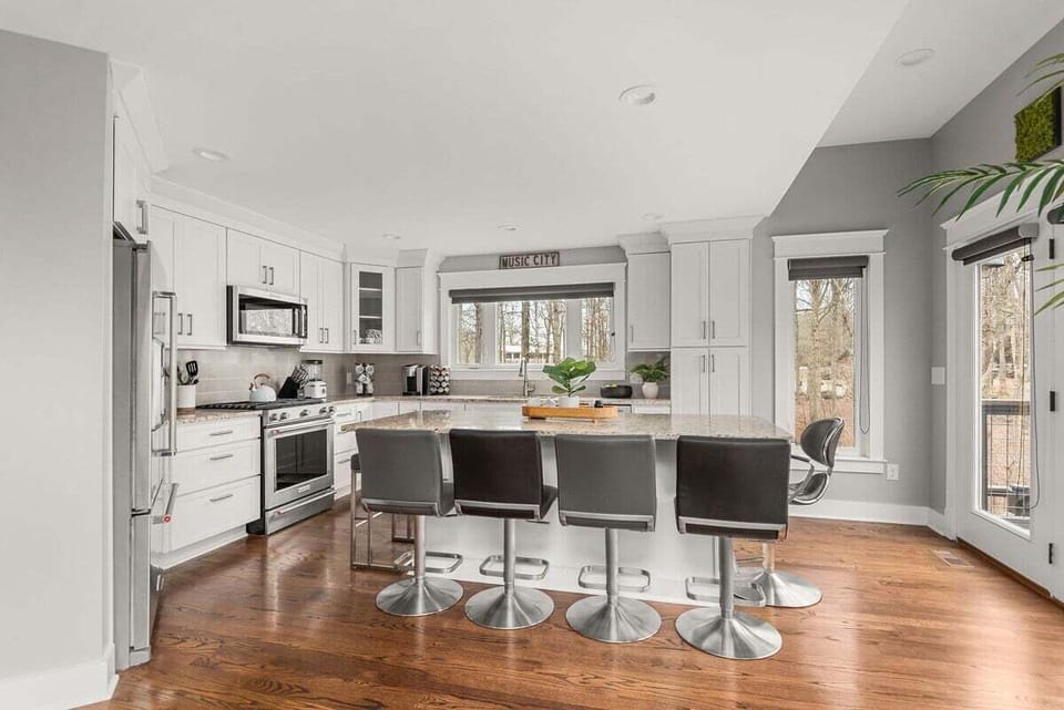 Kitchen area with island for dining and all stainless steel appliances