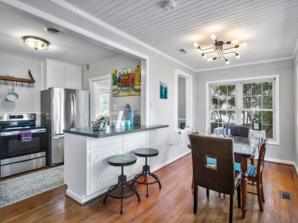 Bright dining space with seating and a desk for remote work. Start your morning with sunlight streaming through glass doors, or step out to sip coffee on the private fenced patio. Barstool seating at the kitchen counter adds extra flexibility.