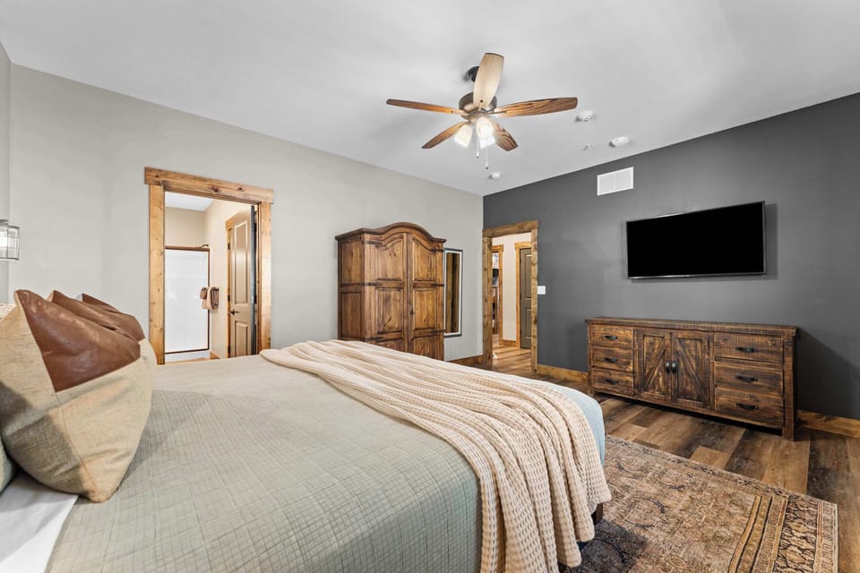 The wood wardrobe and dresser add luxury to this main bedroom!