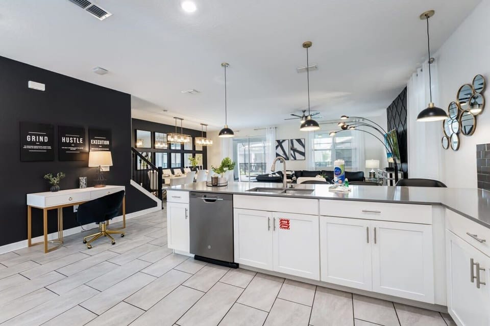 Spacious modern kitchen with a generous island, sleek pendant lighting, and an open layout flowing into the dining and living areas for easy group entertaining.