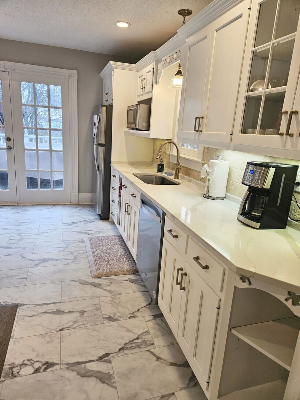 Bright, spacious kitchen featuring a large center island with seating for three—perfect for casual meals or morning coffee. Filled with natural light and modern finishes, it’s designed for both cooking and gathering.