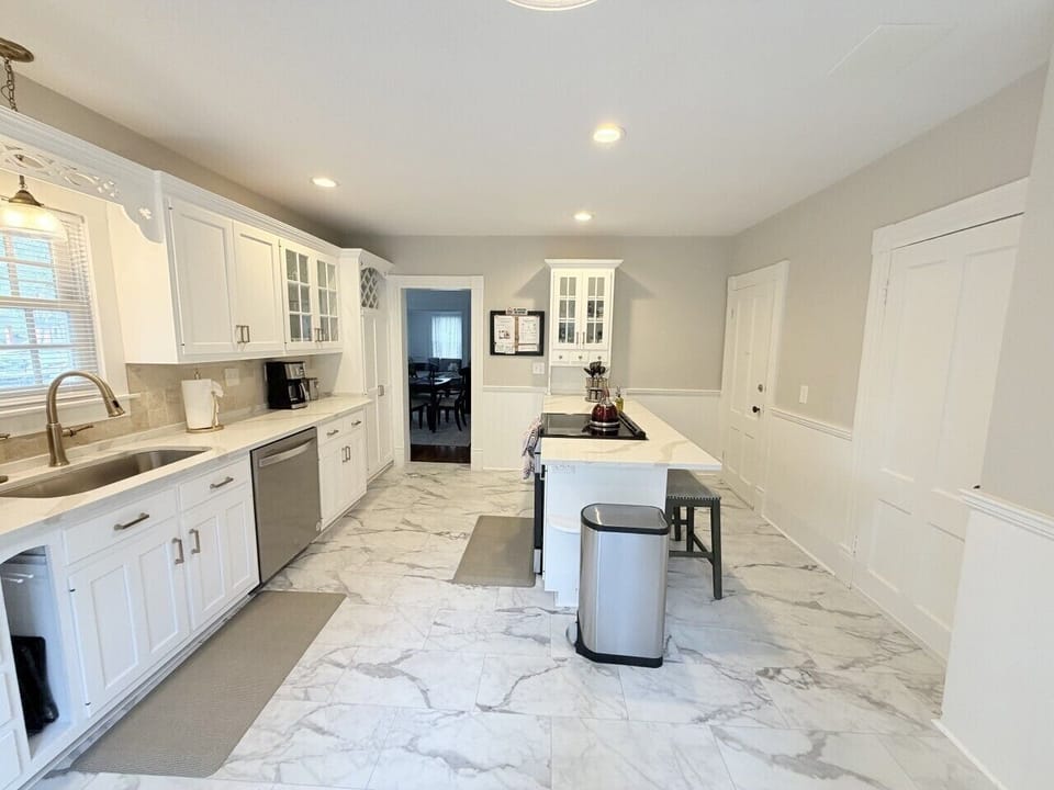 Bright, spacious kitchen featuring a large center island with seating for three—perfect for casual meals or morning coffee. Filled with natural light and modern finishes, it’s designed for both cooking and gathering.