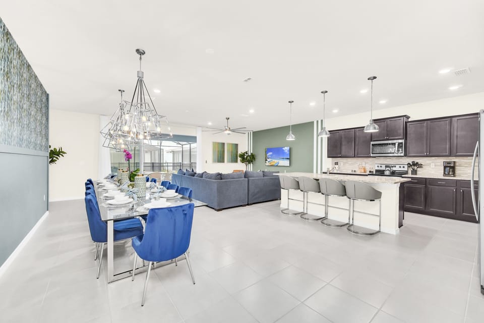 Modern decor in downstairs living area including comfy sectional sofa, spacious dining table, and updated kitchen