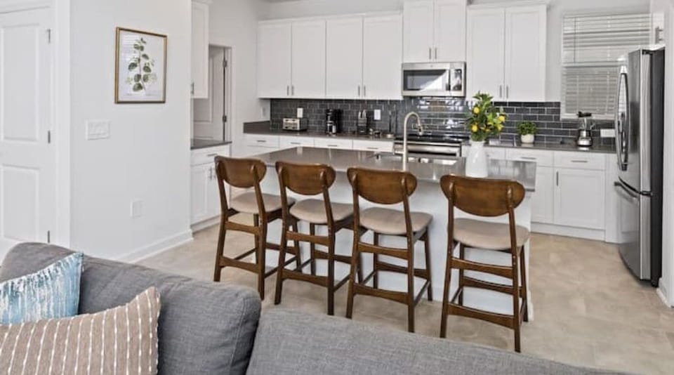 Breakfast Bar that Seats 4 People & Kitchen in Back Ground