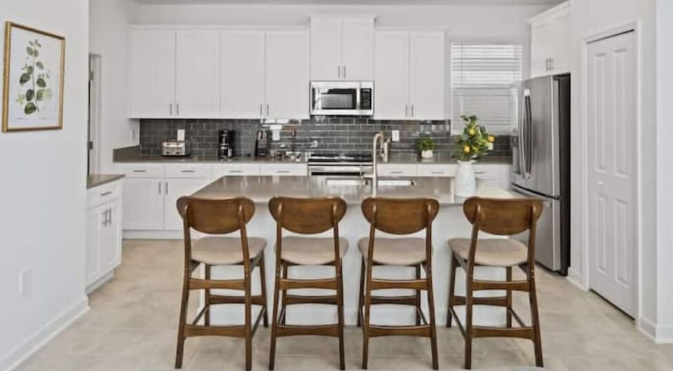 Breakfast Bar that Seats 4 People & Kitchen in Back Ground