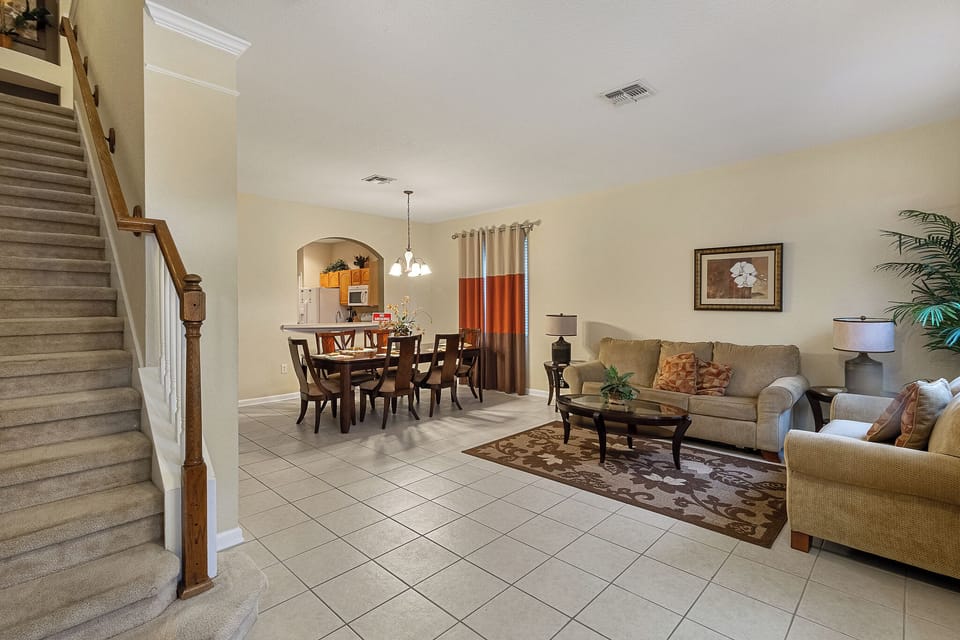 Front Living Room With Stairs Leading Upstairs & Dining Area In Background