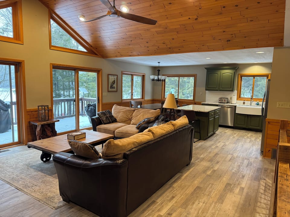 Open living, dining, kitchen opens to lakeside deck with gas grill.