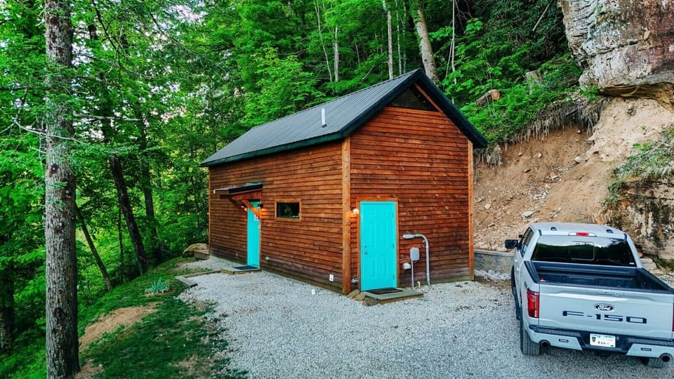 Arrive at this secluded woodland cabin with rustic charm, gravel parking, and a peaceful setting tucked into nature.