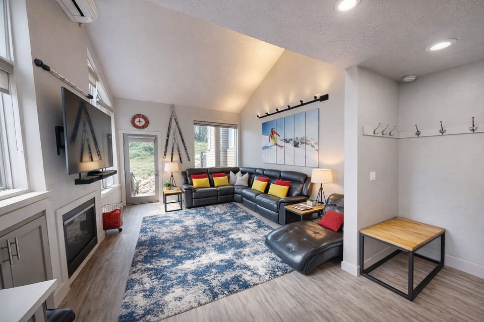Unwind in this sun-drenched living room featuring vaulted ceilings, a cozy fireplace, and a plush sectional.