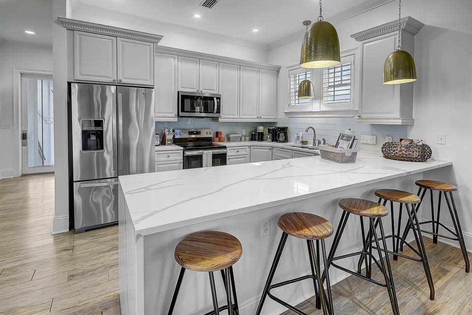 First Floor Kitchen with four stools at the kitchen counter. Entertain in style while your family and friends are perched at the kitchen counter—where conversations flow and culinary adventures begin.