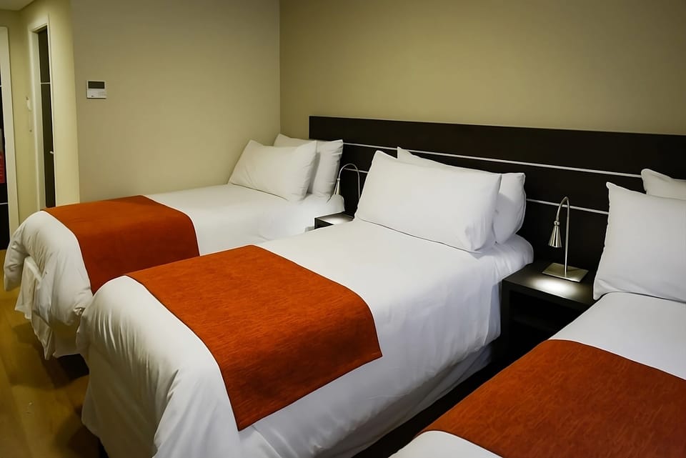 Drift off in inviting beds with warm, soft lighting.
