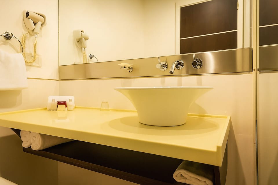 Refresh at the modern sink with plush towels within reach.