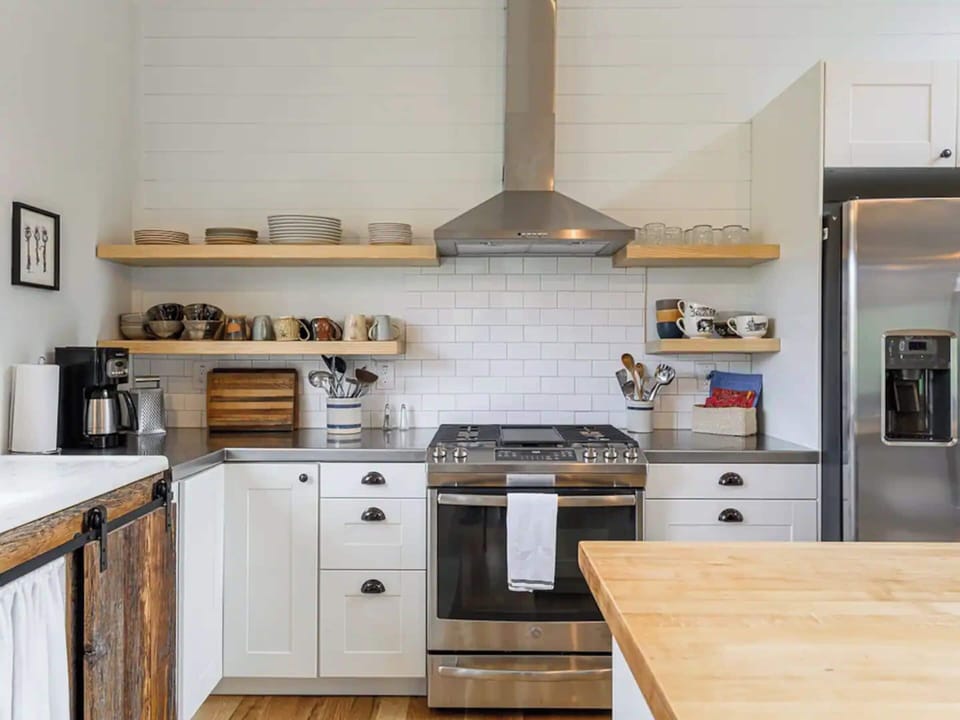 The fully equipped kitchen's elegant marriage of white and wooden accents creates an atmosphere that is both contemporary and inviting.