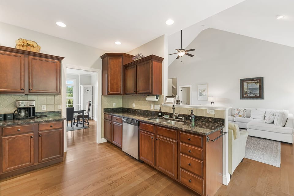 Spacious and functional granite countertops and a dishwasher.