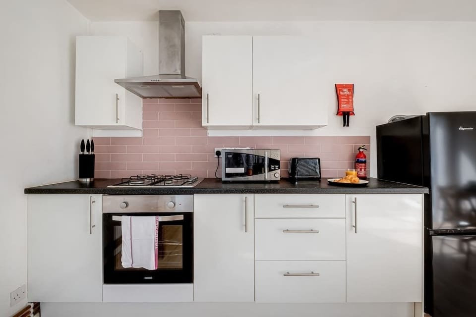 A sleek, modern kitchen fully equipped with everything you need, plus a cosy dining table with 3 chairs for enjoying your meals or casual conversations