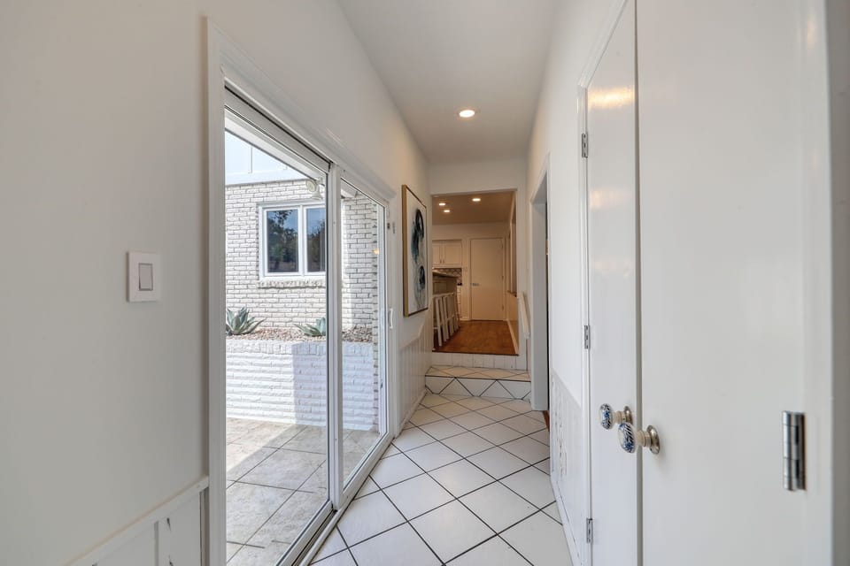 Sliding doors to outside patio and hallway to kitchen