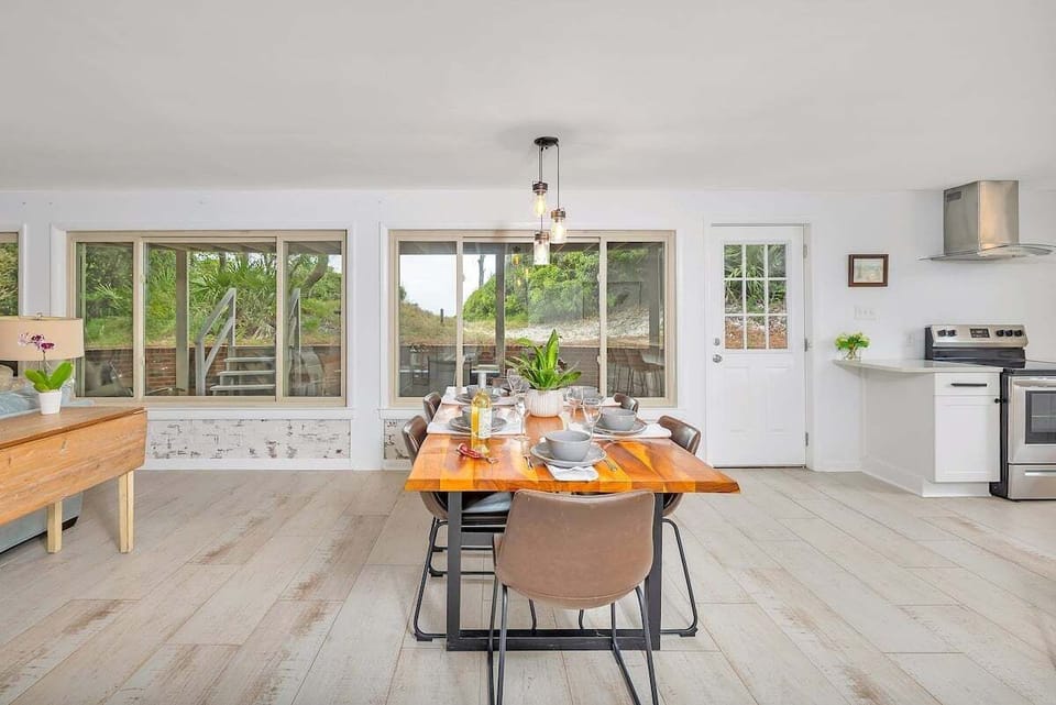 Open dining and kitchen area with wood table and pendant lights
