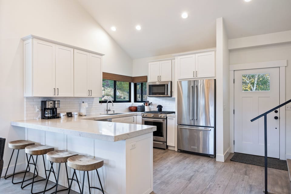 Beautifully designed kitchen with crisp white cabinetry, modern appliances, and a large island with bar seating. A functional and stylish space ideal for cooking and entertaining.