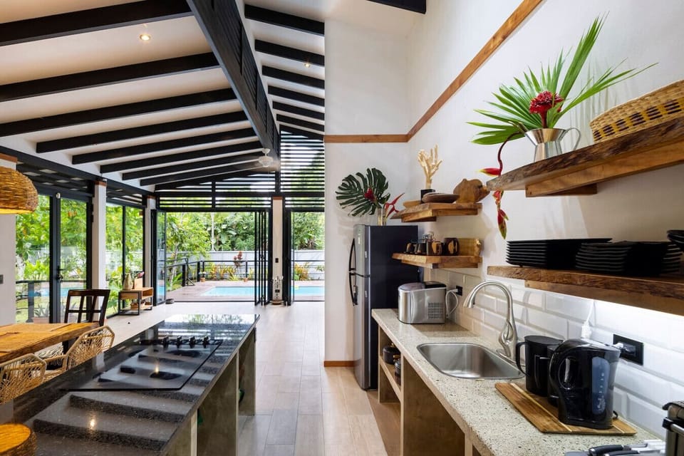 Open-concept kitchen with island and direct access to the terrace and pool in Puerto Viejo, Casa Kali