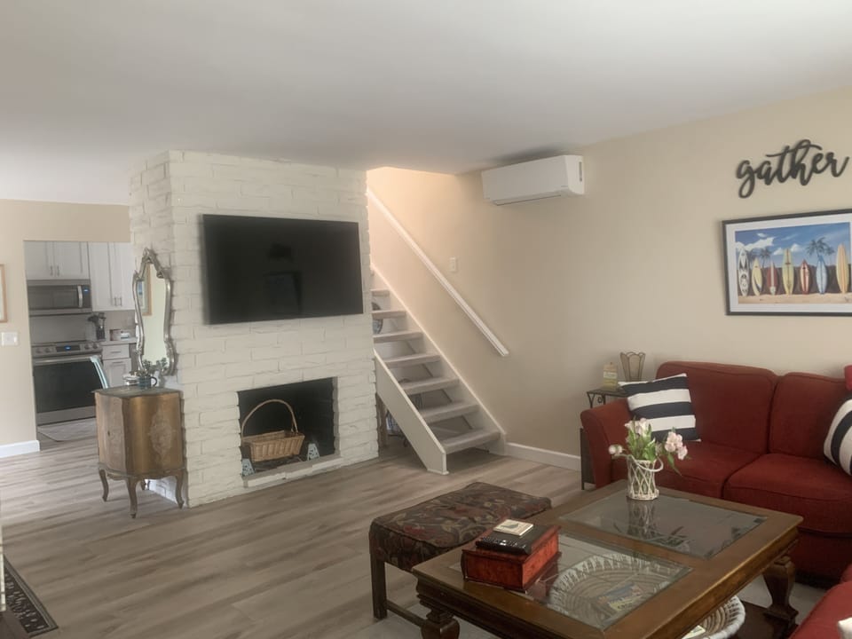 Large screen tv and stairway leading to rooftop deck