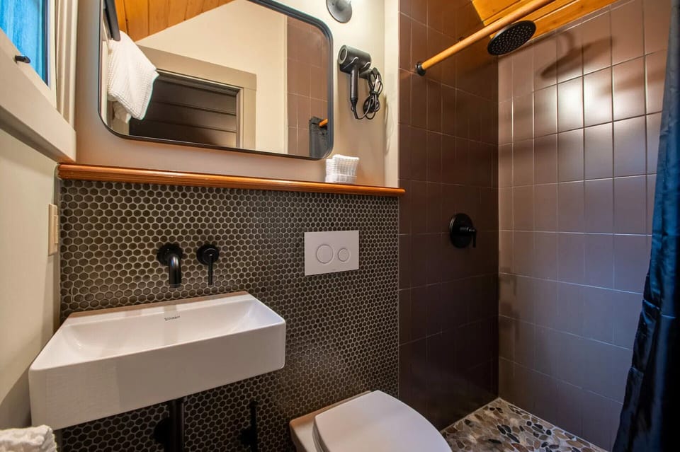 Rinse off comfortably with modern tile and a rainfall shower.