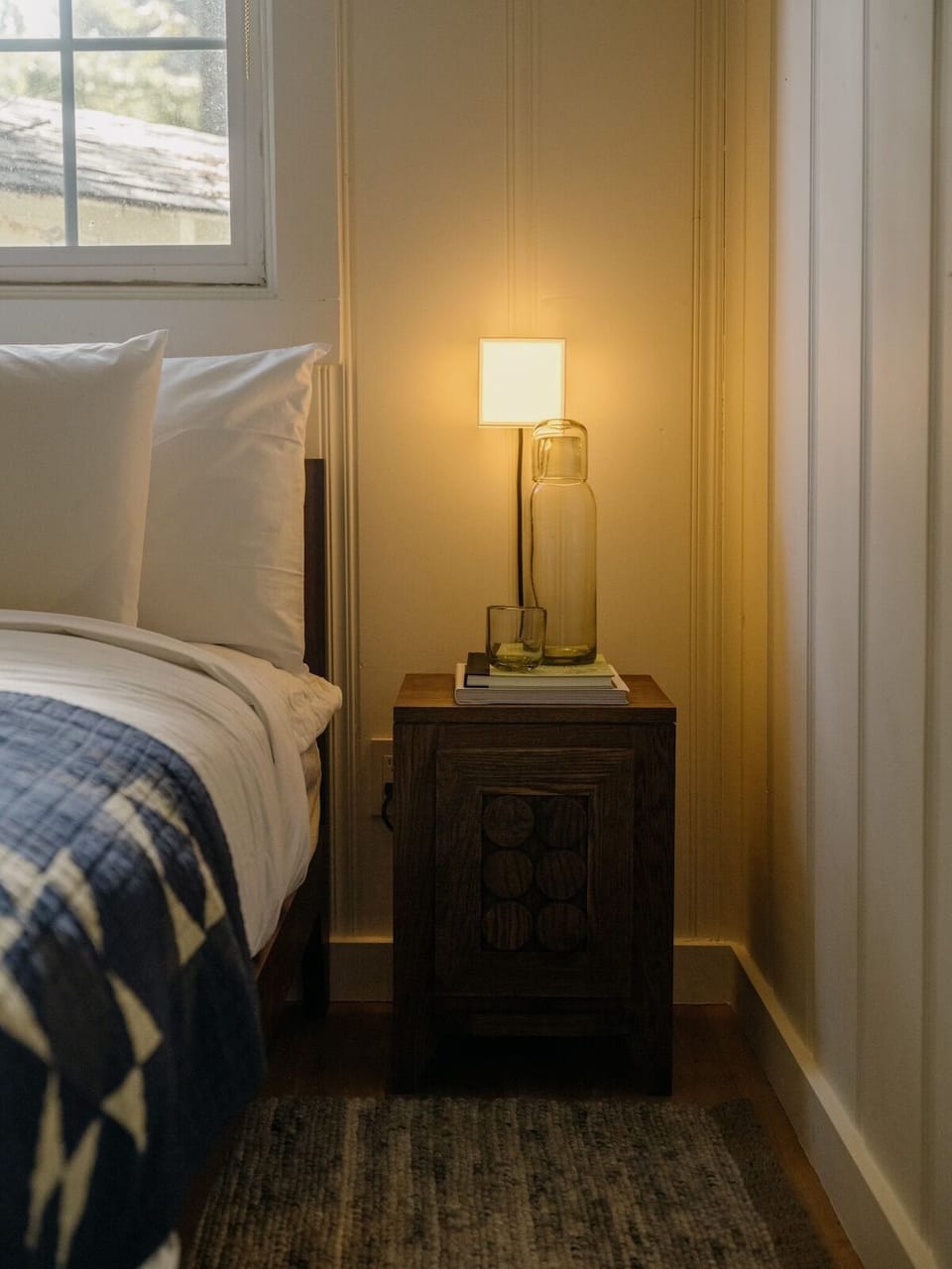 Drift off beside a softly glowing lamp and cozy textures.
