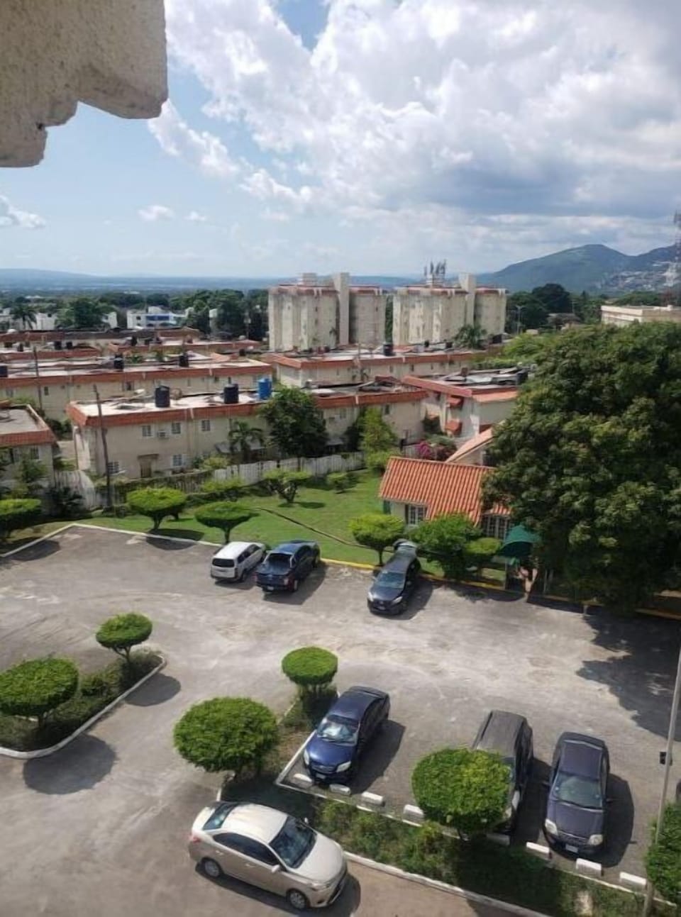 Parking Lot decorated with neatly trimmed trees and  backgroud manicured lawns. 