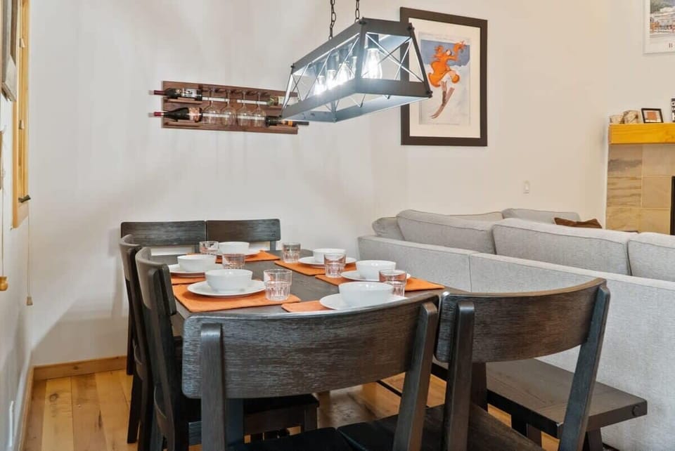 The dining area is located directly behind the living room and features a large table with seating for 8 situated underneath a modern light fixture.