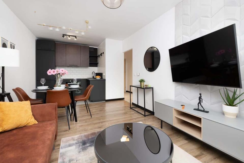 A wide-angle shot of the living and dining area, highlighting the connection between the spaces and the warm, modern decor.

