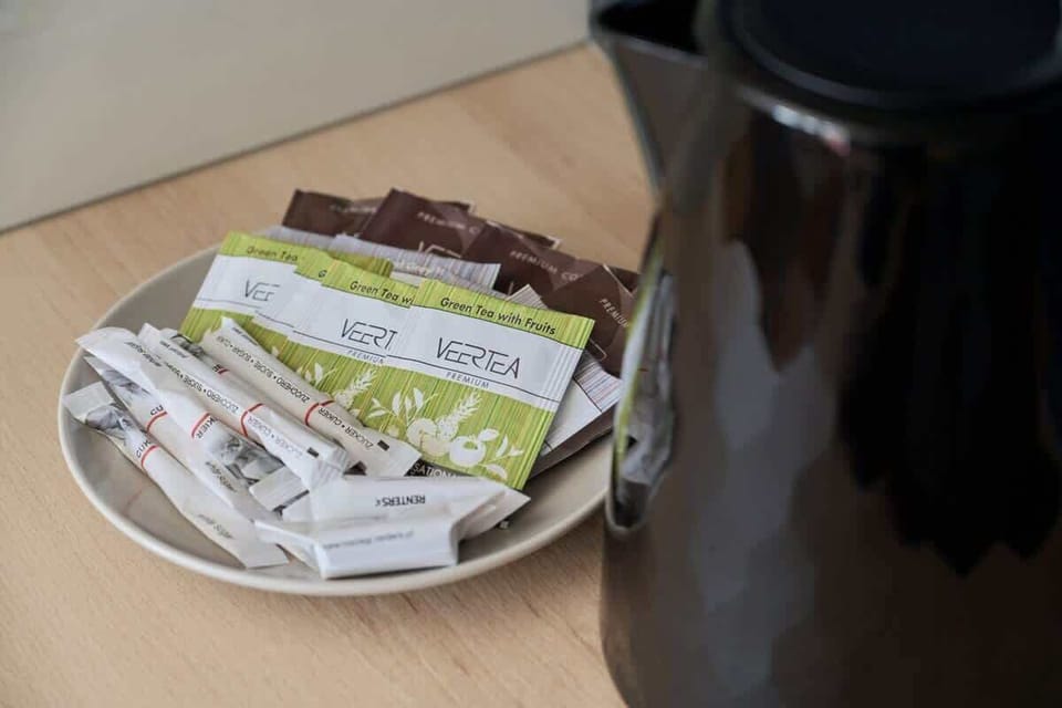 A small detail shot of a plate with tea packets and a black kettle, adding a personal and welcoming touch.

