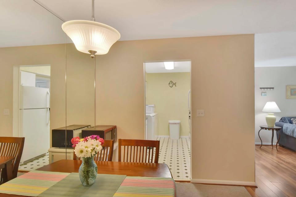 Dining Area Looking into Kitchen and Laundry - Bright, open, and vacation-ready—this dining space seats four comfortably and flows right into the kitchen and in-unit laundry for effortless living on island time.