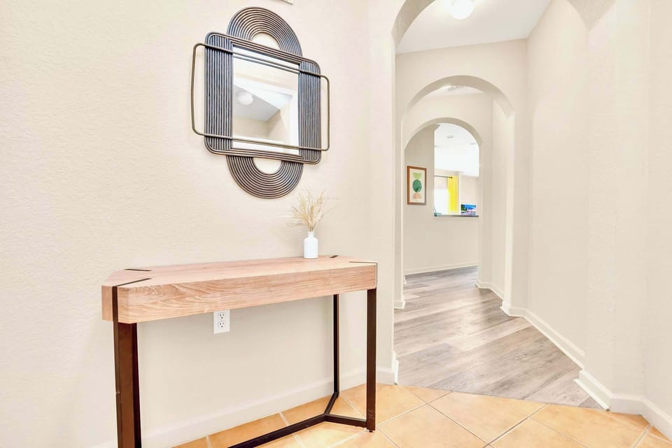 welcoming entryway with a stylish table and mirror to greet you