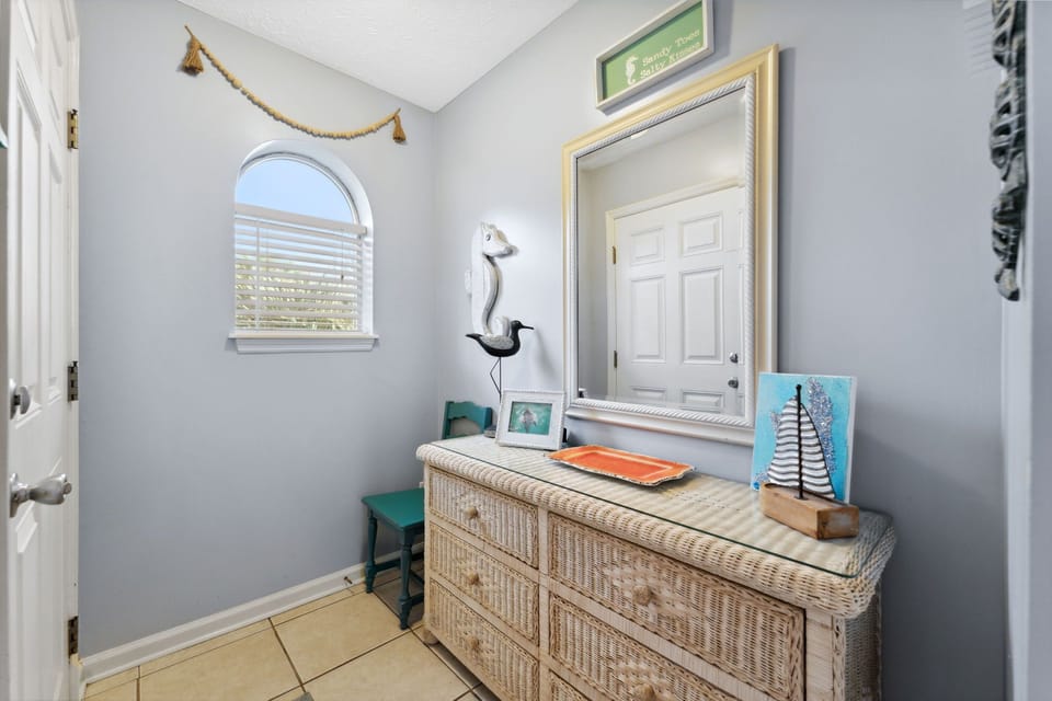 Cozy entryway with wicker dresser and nautical decor.
