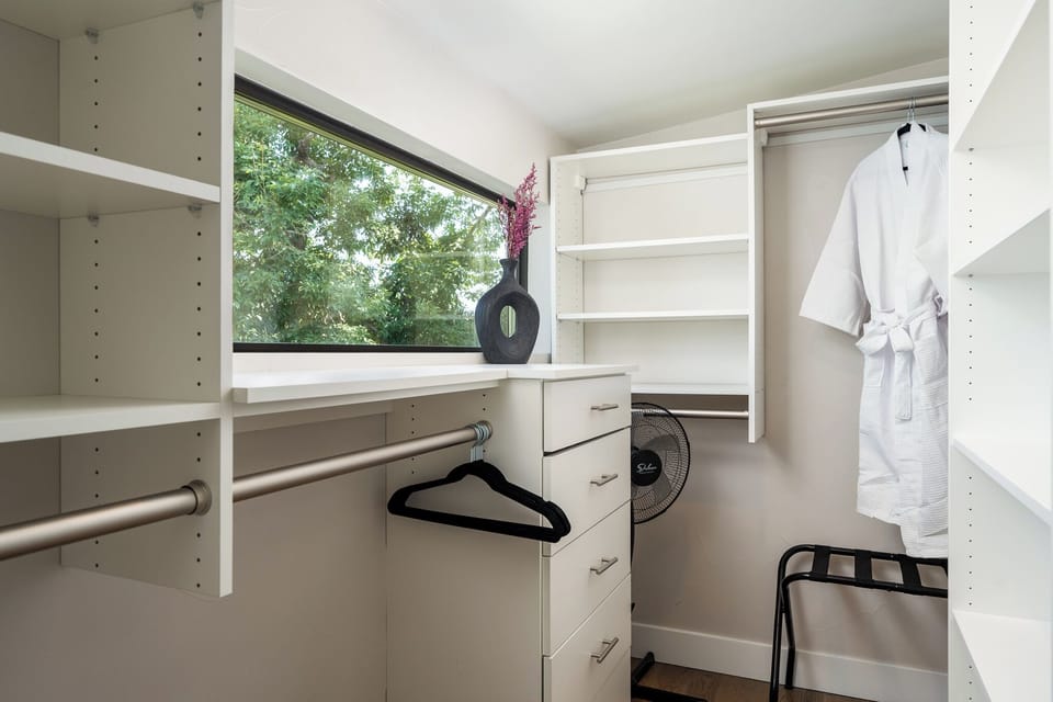 Primary Suite 1 spacious closet with robes and luggage rack.