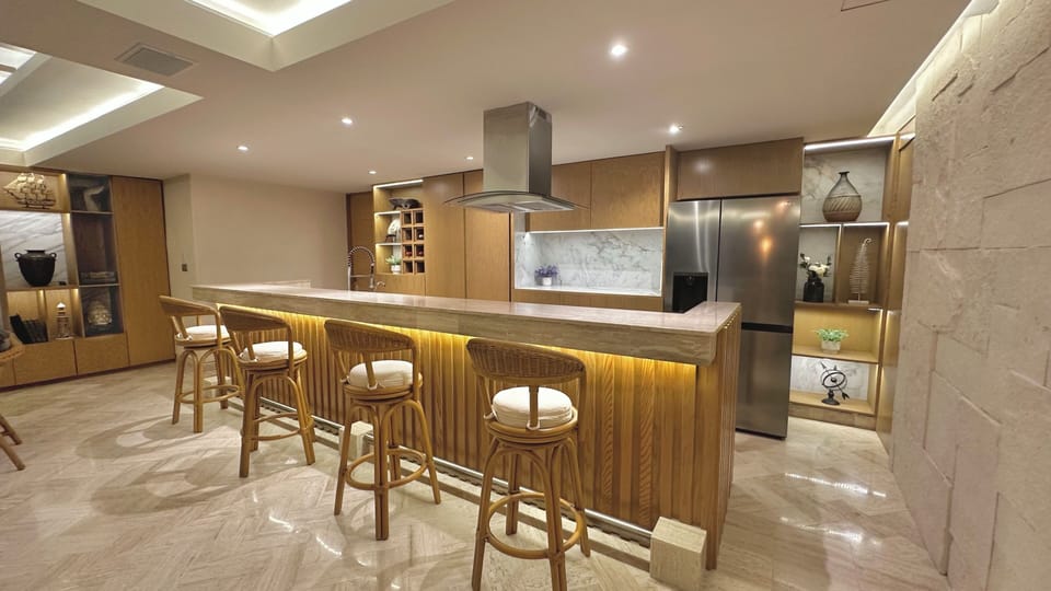 Large kitchen with bar and high benches, with a privileged view of the sea.