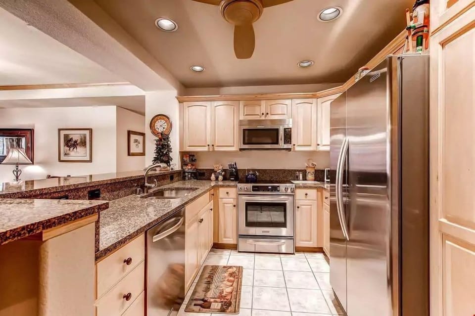Prepare your meals in the fully-equipped kitchen featuring modern stainless steel appliances and granite countertops
