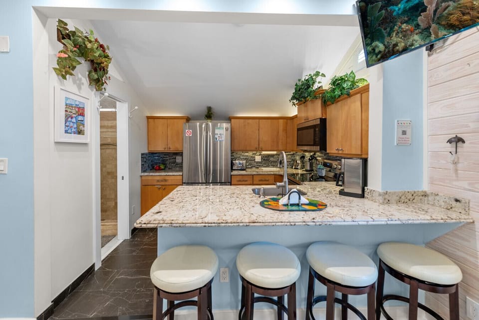 Cushioned, swivel bar stools overlooking the kitchen.  