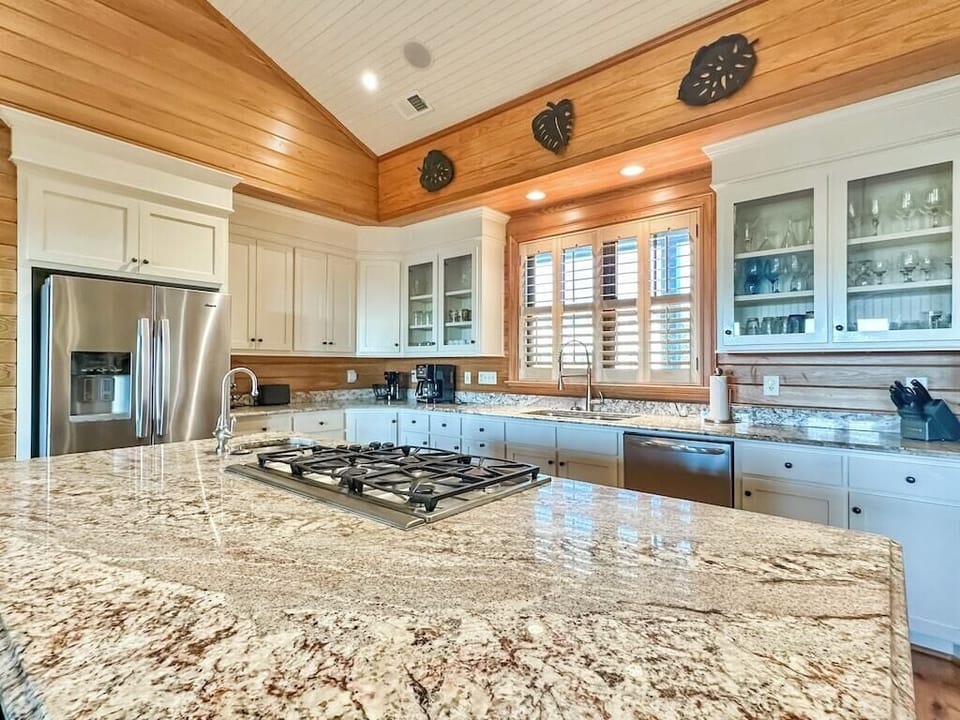 A large chef's kitchen with a granite island large enough for food preparation and seating.