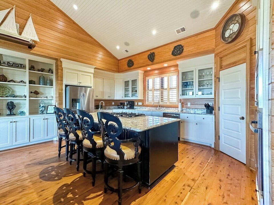 A large chef's kitchen with a granite island large enough for food preparation and seating.