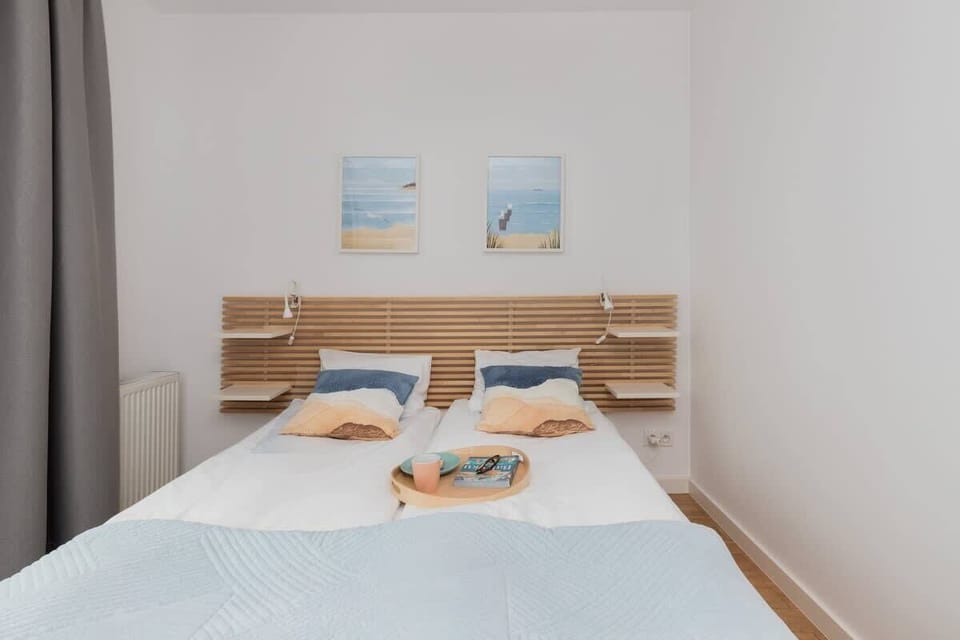 A second bedroom angle showing the wooden bed frame and coastal-inspired décor.

