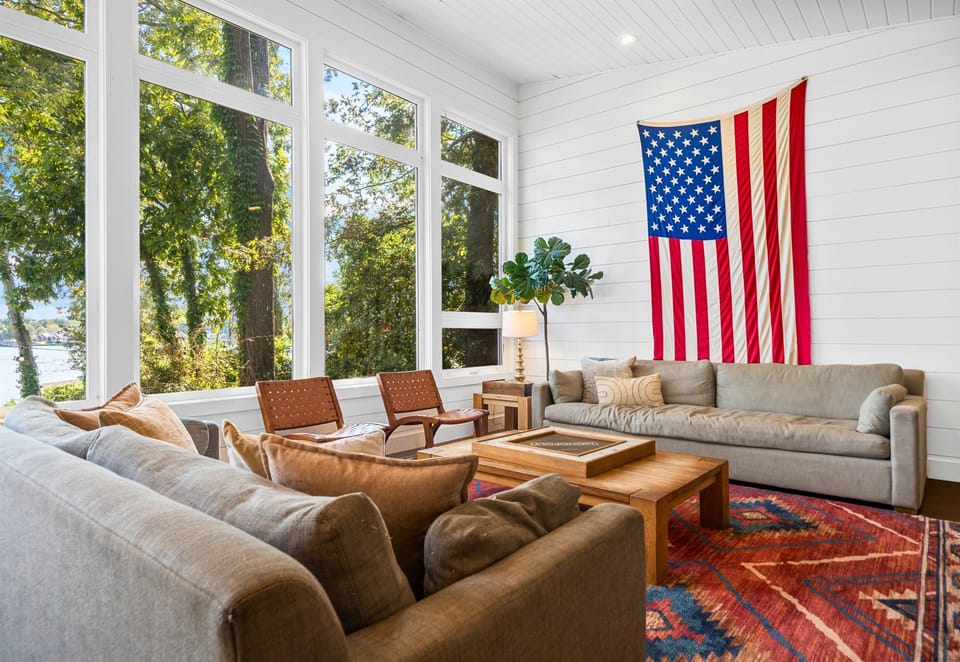 Living room with big comfy couches and floor-to-ceiling windows on the lake.