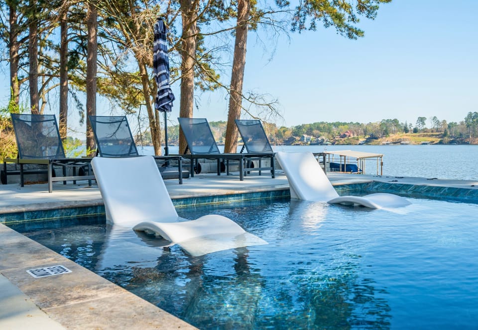 Take in the modern pool design as it extends toward the lake, blending clean lines with natural surroundings for a truly relaxing backdrop.
