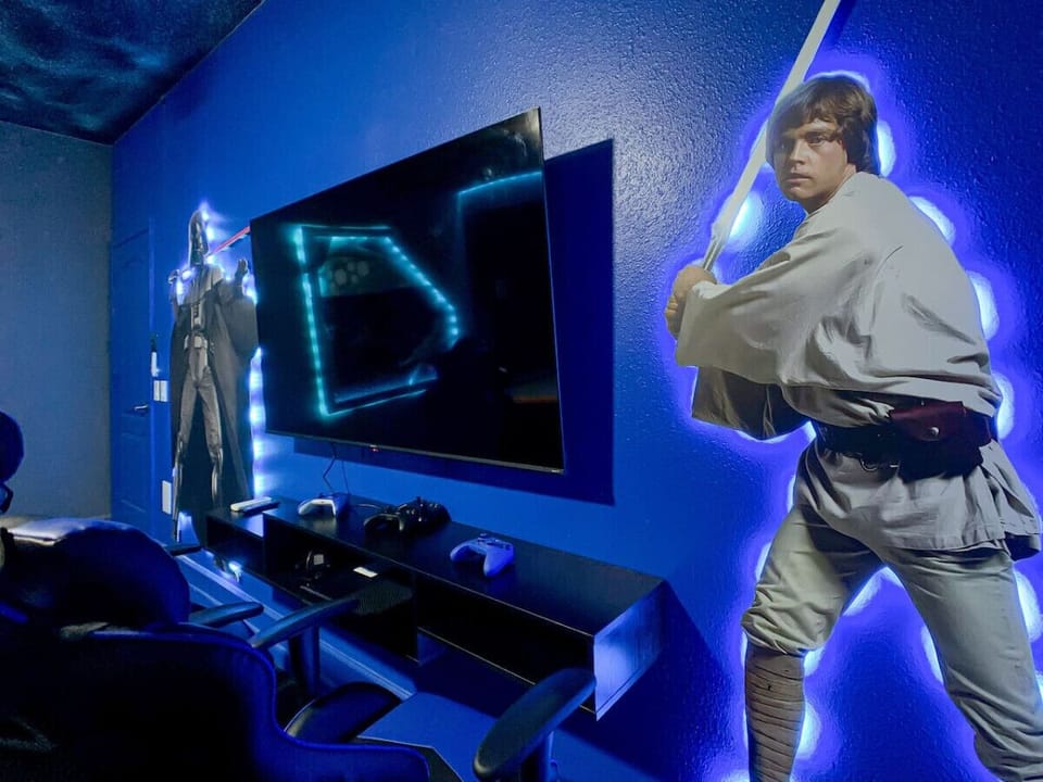 Entertainment corner with large TV, gaming consoles, and themed décor.