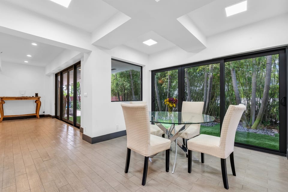 Take a seat around the elegant glass table and enjoy calming views of the private garden, complete with palm trees and a meticulously manicured lawn.
